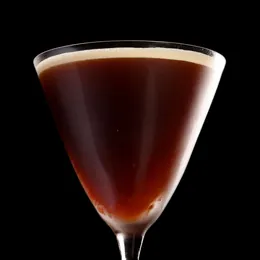 A dark coffee cocktail in a martini glass