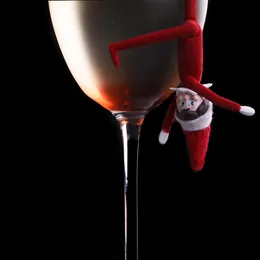 A toy elf hanging from the rim of a cocktail glass